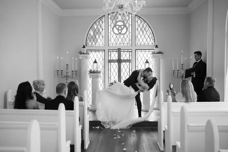 Groom dips bride for first kiss at chapel elopement ceremony