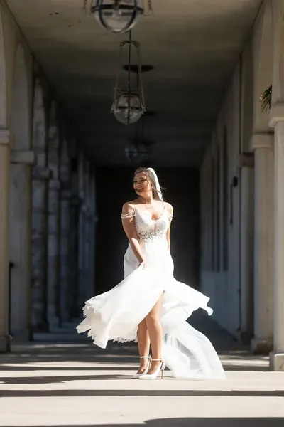 Bride twirling in Flagler College colonnade with dress flowing