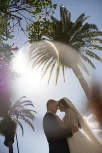 Couple kissing under palm trees with sun flare in St Augustine