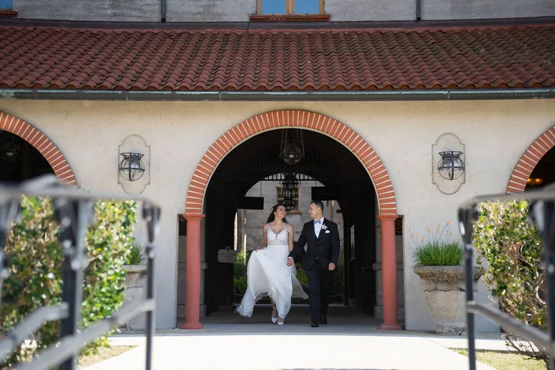 Couple walking under Spanish arches at Casa Monica St Augustine