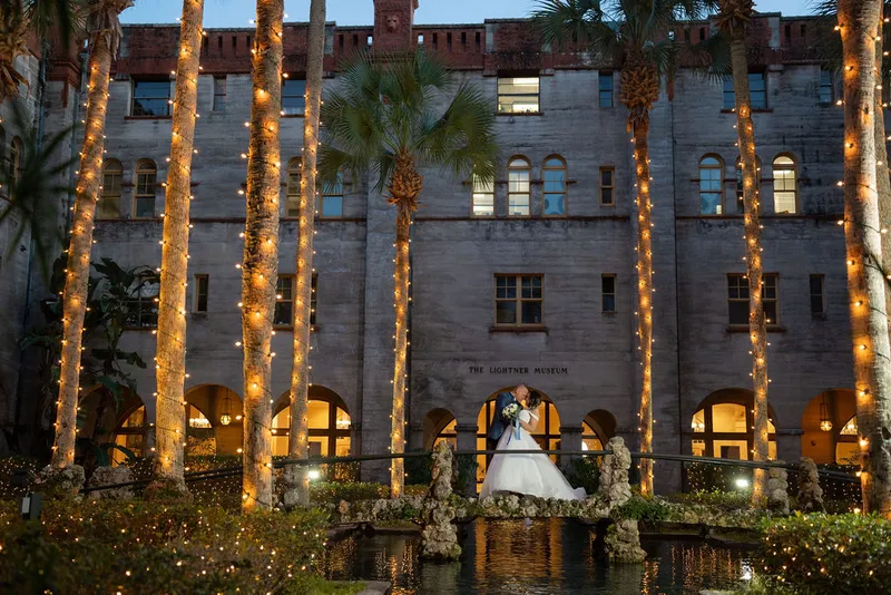 Couple kissing on bridge at Lightner Museum courtyard at twilight
