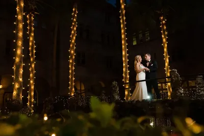 Romantic couple portrait at Lightner Museum with illuminated palm trees