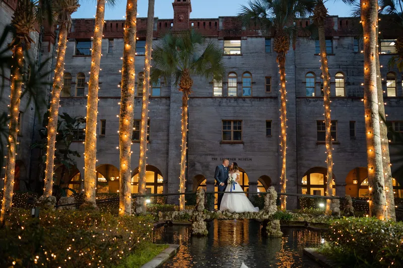 Couple on bridge in Lightner Museum courtyard with lit palm trees