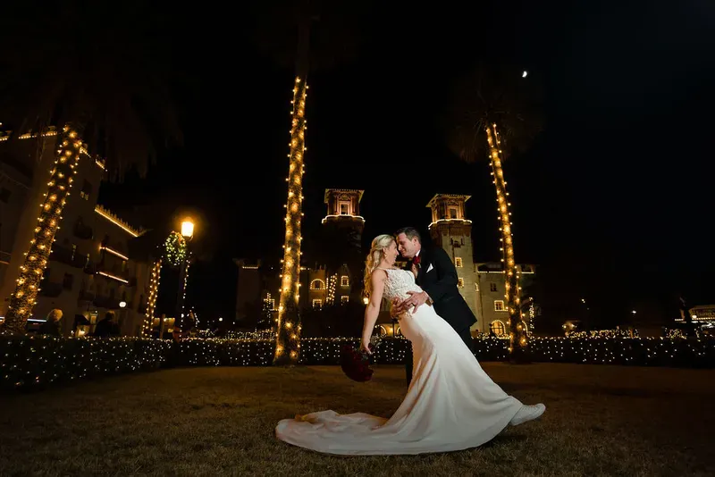 Groom dips bride during Nights of Lights at Lightner Museum