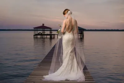 Bridal portrait on dock with flowing veil at St Johns River sunset