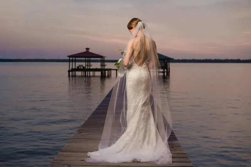 Bridal portrait on dock with flowing veil at St Johns River sunset