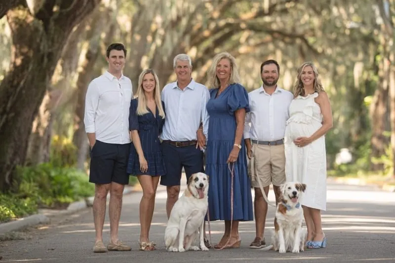Family with dogs portrait on tree-lined street