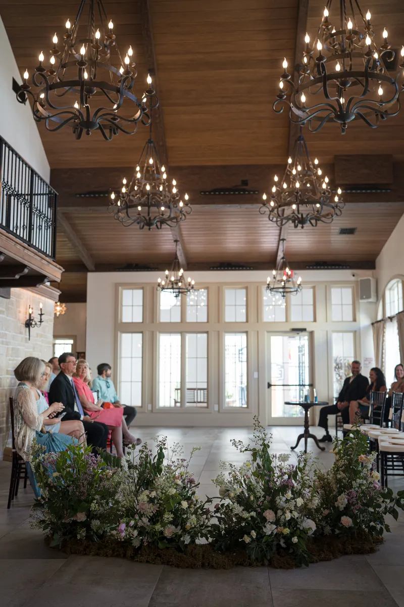 9 Aviles ceremony space with chandeliers and wildflower arrangements