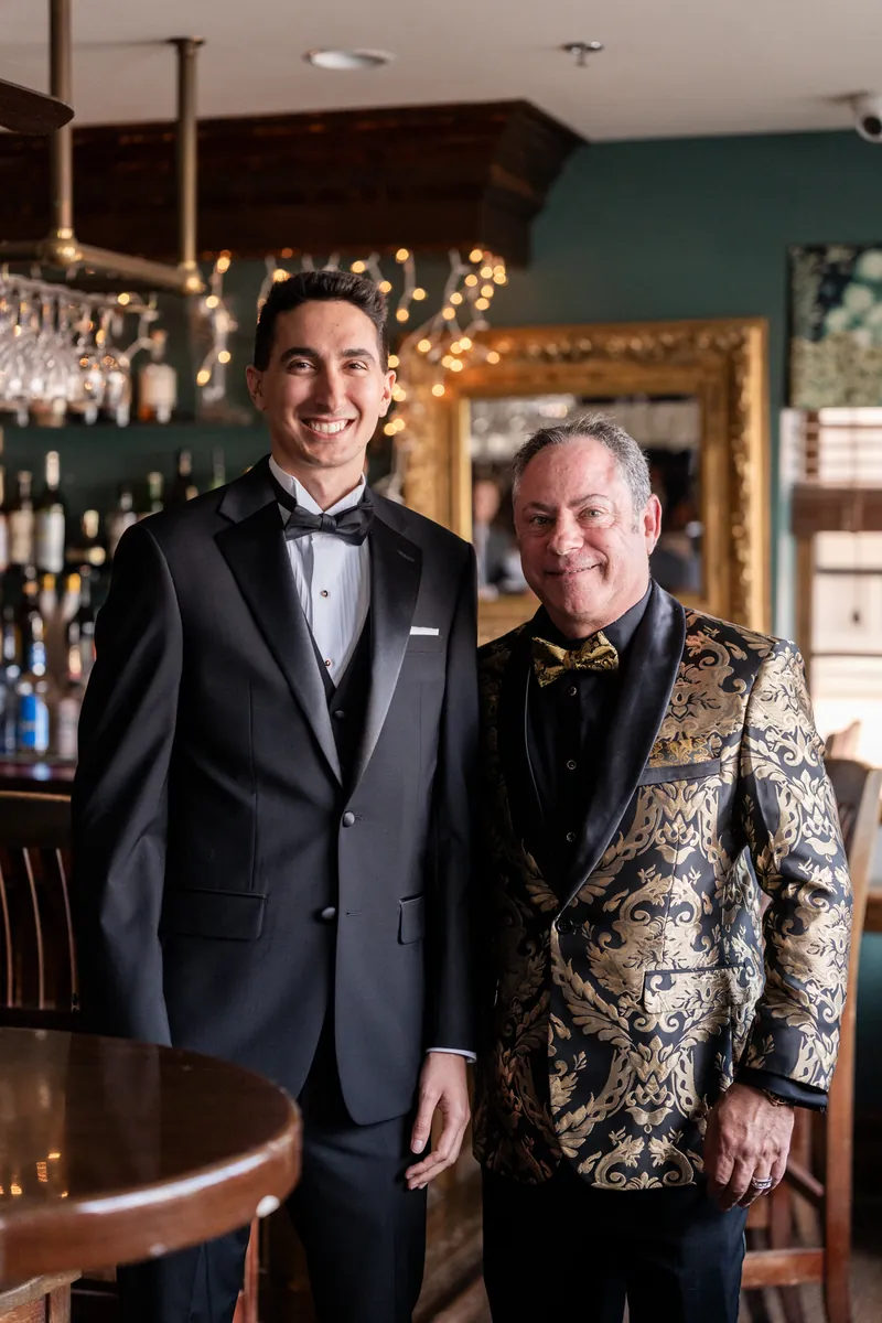 Groom with his father in gold brocade jacket at bar