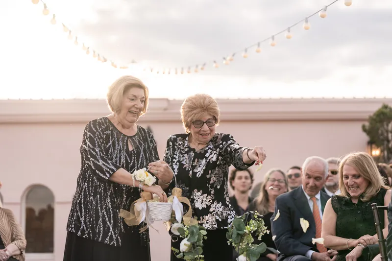 Grandmothers walking the aisle as flower girls tossing petals on the rooftop