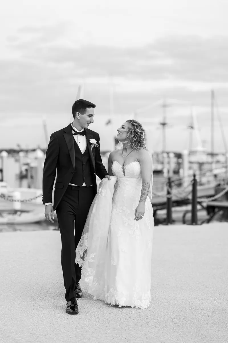 Black and white portrait of bride and groom walking together at the St. Augustine marina