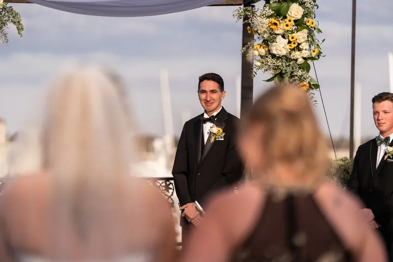 Dino waits at the altar as Alexis approaches in her wedding dress during their ceremony.