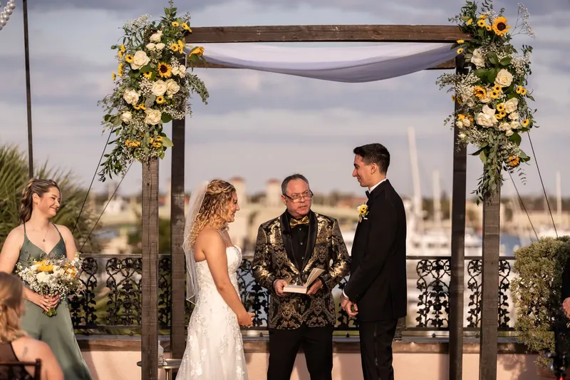 The officiant addresses Alexis and Dino as they stand together at the altar during their ceremony at The White Room, St.