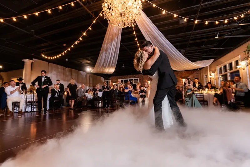 Dino dances with Alexis at The White Room while dry ice swirls across the floor and guests watch beneath string lights