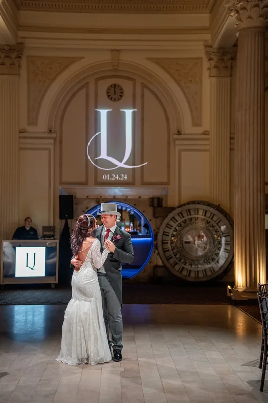 Sam dips Alyson during their first dance under the Treasury's coffered ceiling and illuminated monogram.