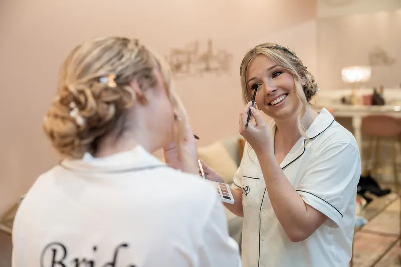 Anna smiles while applying makeup in front of a mirror at The Treasury on the Plaza, St. Augustine.