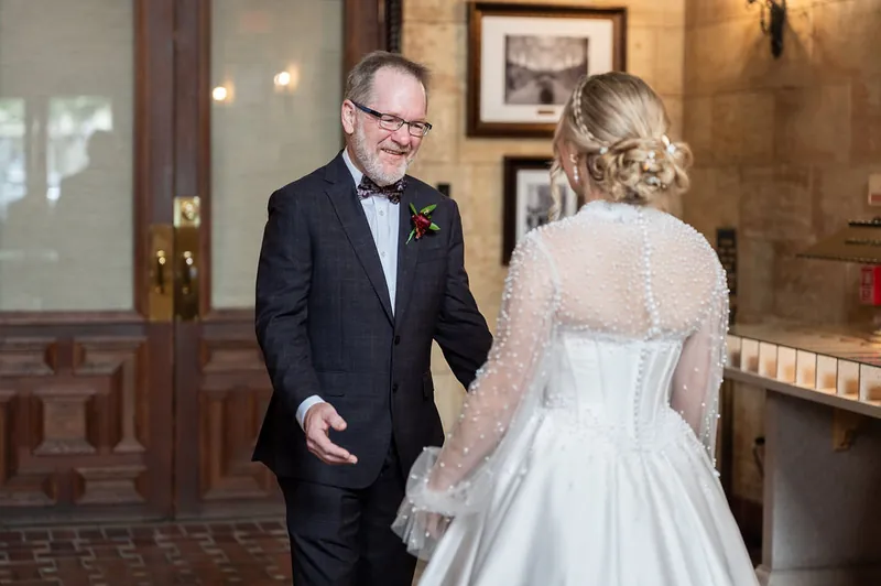 Rafael walks toward Anna in her lace-detailed white gown inside the historic venue.