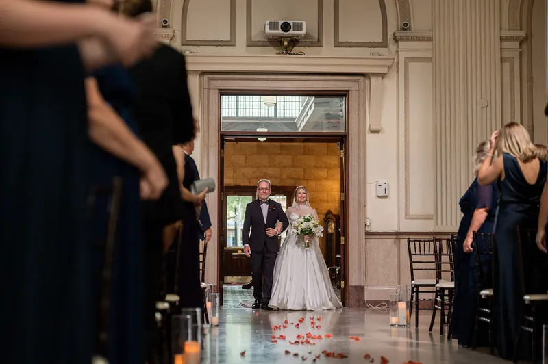 Anna and Rafael stand at the altar as guests watch from the pews during their ceremony.