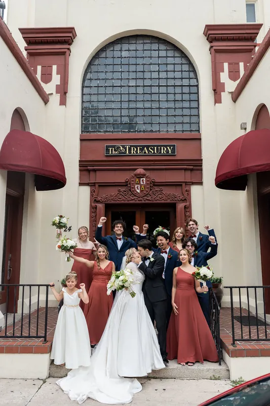 The couple poses with their entire wedding party on the front steps of The Treasury's historic entrance.