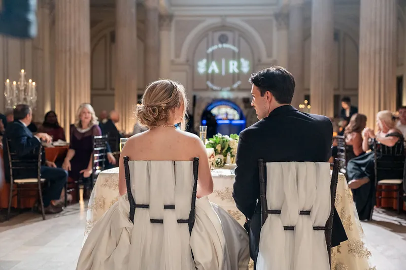 The couple walks down the aisle at The Treasury on the Plaza while guests watch from both sides.