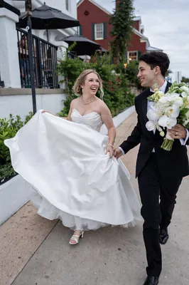 Groom carrying bride in flowing white dress outside historic St. Augustine wedding venue, Treasury on the Plaza