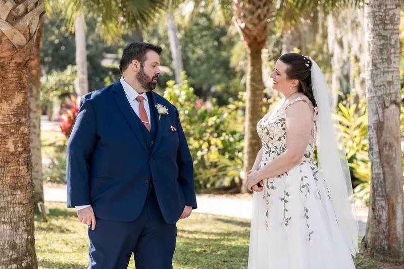Anne and Chase seeing each other for the first time during their first look, standing face to face between palm trees