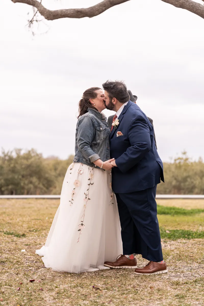 Anne and Chase sharing their first kiss as a married couple beneath the palm trees at Fountain of Youth