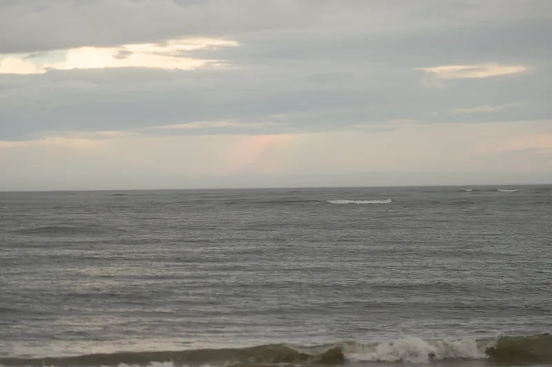 Soft waves roll onto Vilano Beach under an overcast sky at dusk.