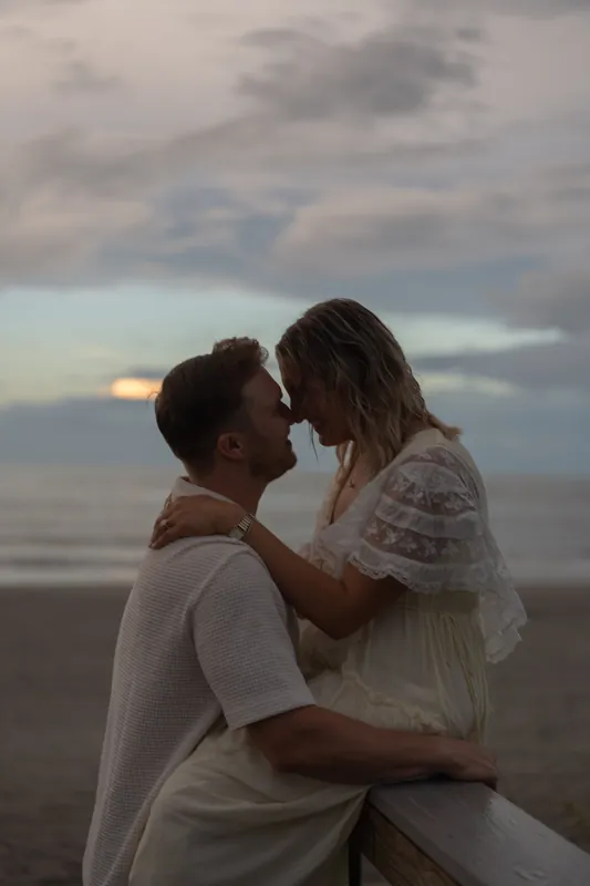 Sitting together on the sand at Vilano Beach, Craig and Ashley kiss as storm clouds gather over the Atlantic.