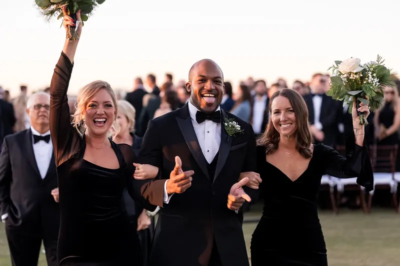 Craig and Ashley walk arm-in-arm with friends in formal attire, all smiling outdoors at Sawgrass Marriott Golf Resort & Spa.