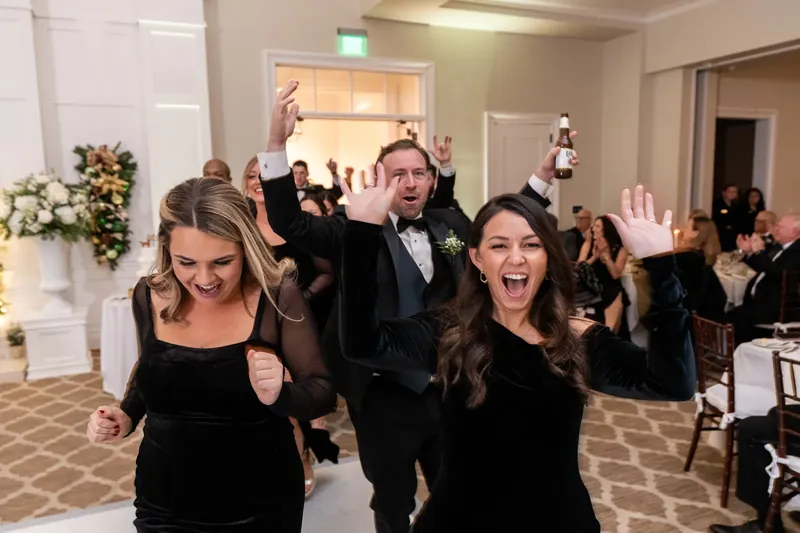 Guests cheer with arms raised as Ashley and Craig dance surrounded by the crowd.