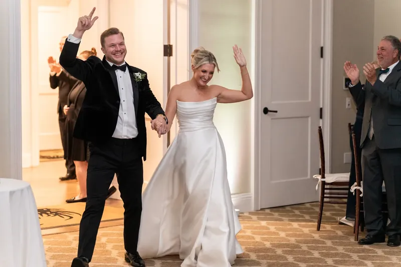 Craig and Ashley dance with arms raised while guests applaud in the ballroom at Sawgrass Marriott Golf Resort & Spa.