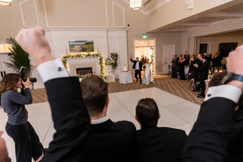 Guests raise their fists and cheer from the dance floor during the reception at Sawgrass Marriott Golf Resort & Spa.