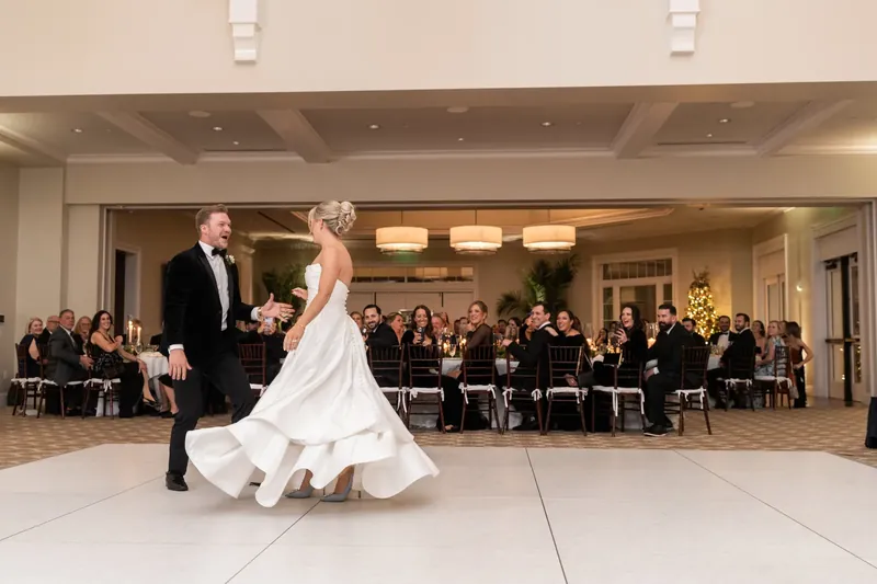 Craig spins Ashley across the dance floor as seated guests watch during their first dance at the resort.