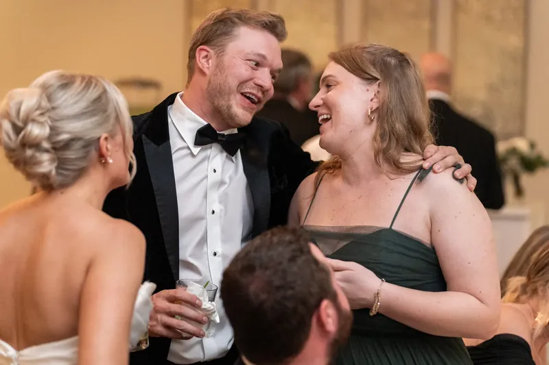 Craig laughs with a guest in a black strapless dress during the reception.