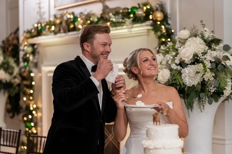 Craig and Ashley share their first bite of white cake, smiling at the Sawgrass Marriott during their reception.