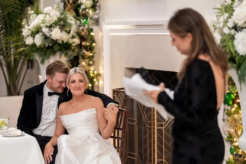 Ashley and Craig watch as someone speaks during the toasts and reception.