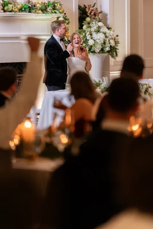 Craig stands at the altar beside Ashley in a white gown, exchanging vows before guests and white floral arrangements.