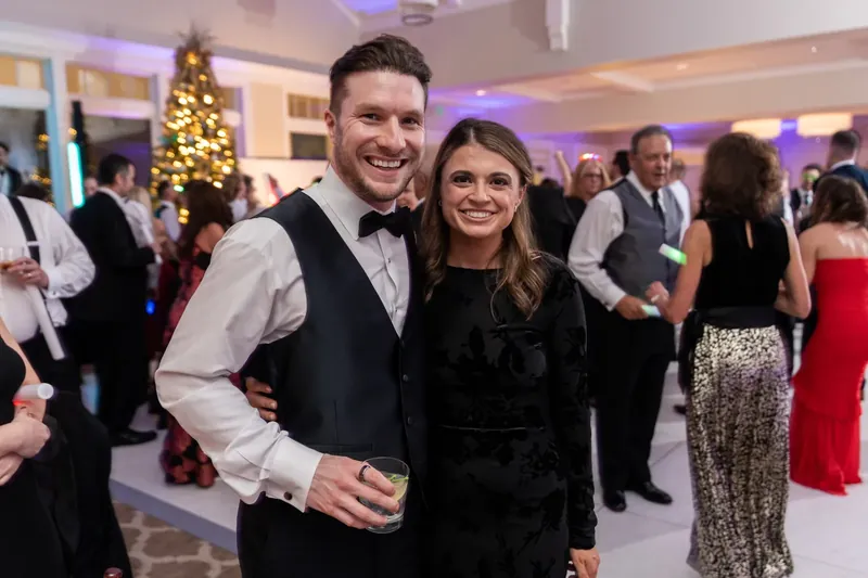 Craig and Ashley pose together in formal attire, smiling at the camera during the reception.
