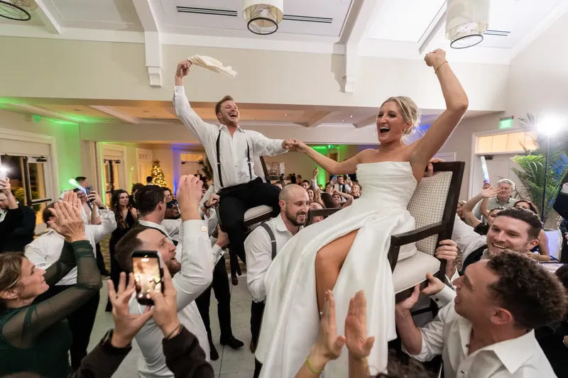 Craig and Ashley lift their arms in celebration as guests cheer during their first dance.