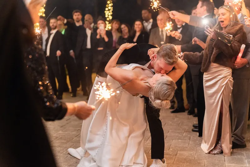Craig dips Ashley in her white wedding dress as guests cheer with sparklers at the Sawgrass Marriott Golf Resort & Spa.
