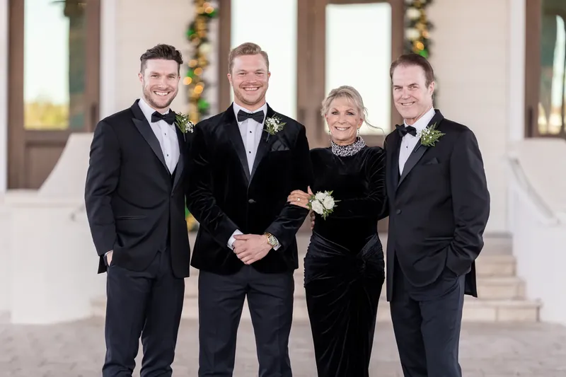 Craig stands with three male family members in tuxedos on the resort's white colonnade.