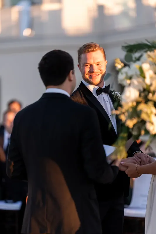 Craig smiles while standing at the altar as a guest approaches during the ceremony.