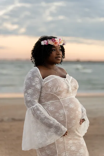 St. Augustine maternity photographer captures expecting mother in lace dress at beach sunset