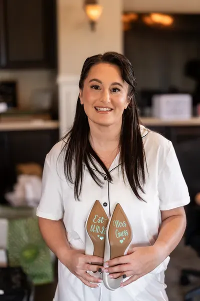 Ashley and Jordan sharing a kiss on the staircase surrounded by lush greenery at Crosswater Hall