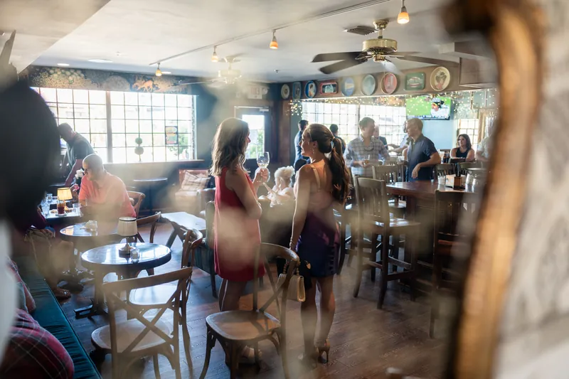 Guests mingle and chat throughout the dining room during the rehearsal dinner at The Chatsworth Pub and Tea Room.