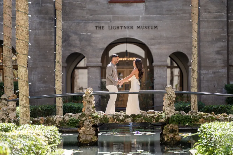 Beltran and Gabriela embrace near the reflecting pool as one person leans in for a kiss.