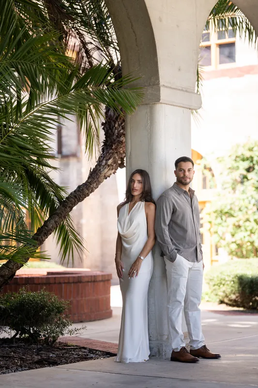 Standing beneath a palm tree in the museum courtyard, they pose side by side with soft smiles, framed by tropical foliage and colonial architecture.