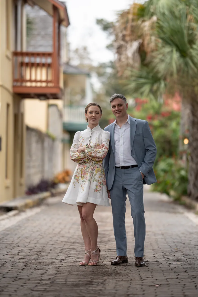 Couple walking on cobblestone street with Spanish balconies