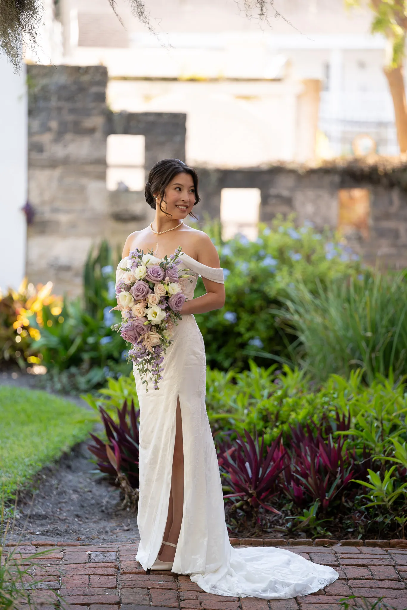 Bride Binh portrait with lavender and blush cascading bouquet in the Oldest House garden